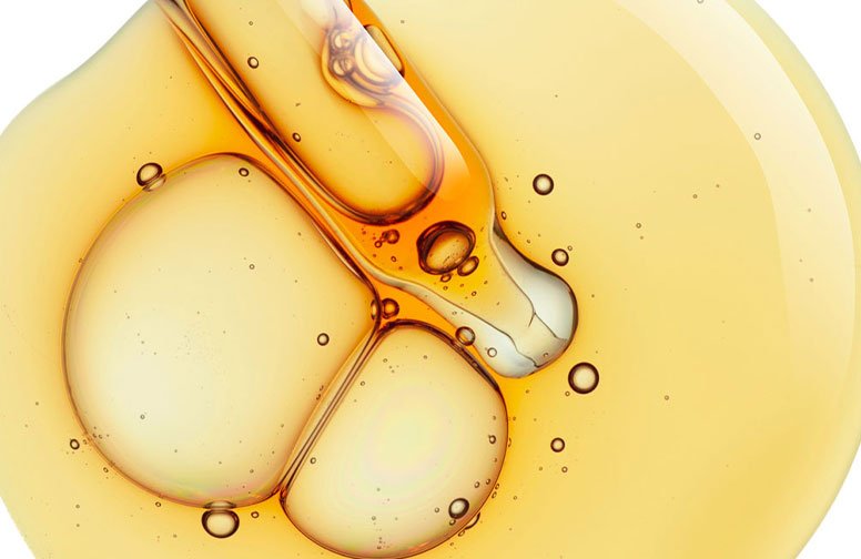 Öl-Textur mit gelben und goldenen Tönen, repräsentiert Retinol und Bakuchiol, wichtige Inhaltsstoffe in der Hautpflege für regenerative Eigenschaften.